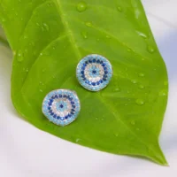 Close up in green background for clear identification of colors of Blue Halo Evil Eye Studs 925 Silver